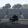 Grand piano on an outdoor amphitheater stage in a scenic setting.